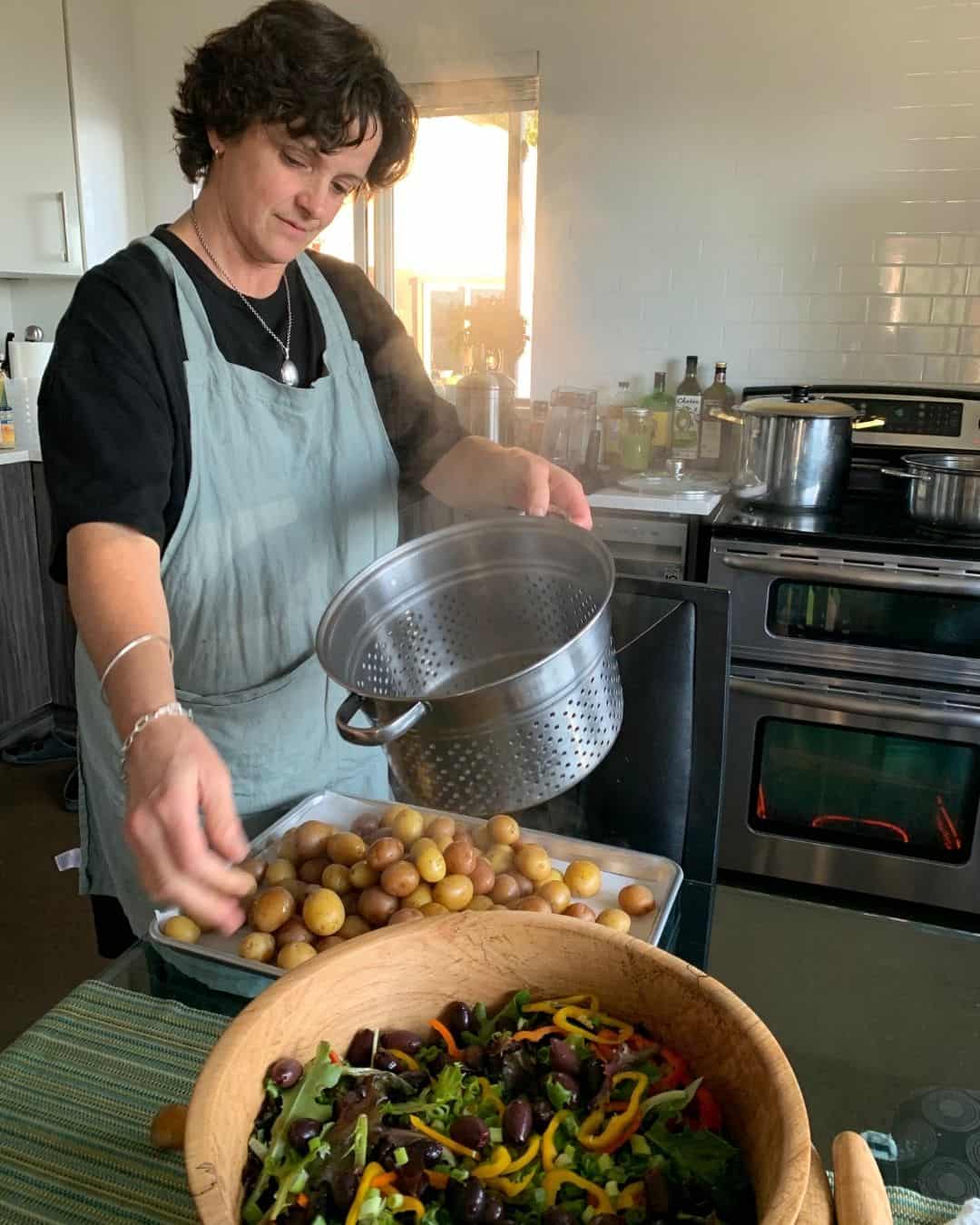 A woman prepares potatoes and salad fresh from the garden