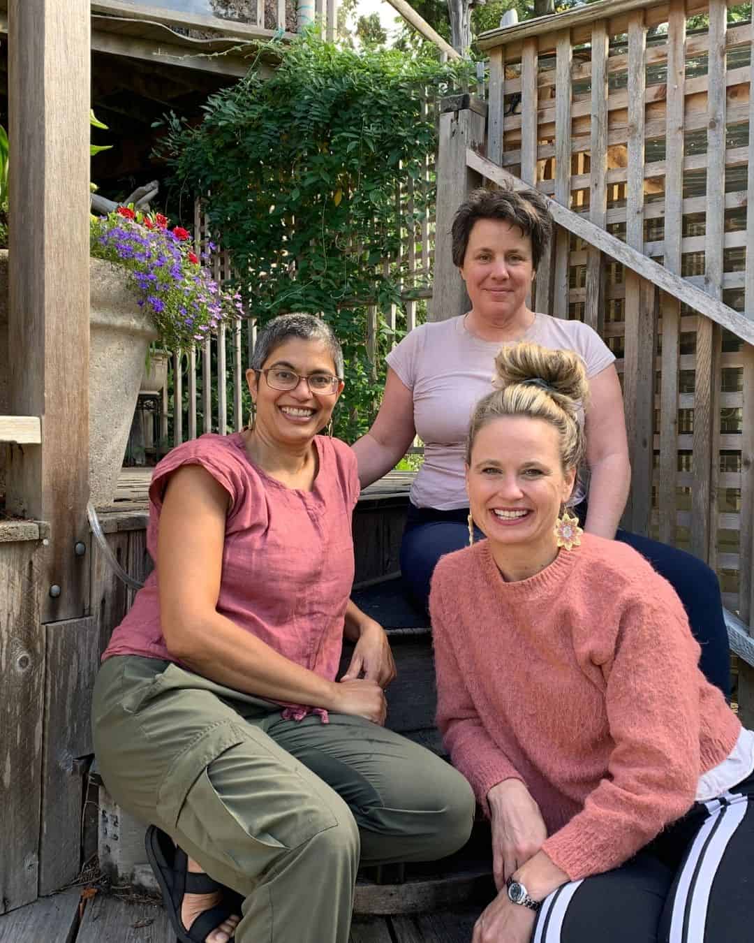 Farah Nazarali, Nicole Marcia and Corrine Mckell sitting on the steps of a BC Yoga Retreat for Health Professionals
