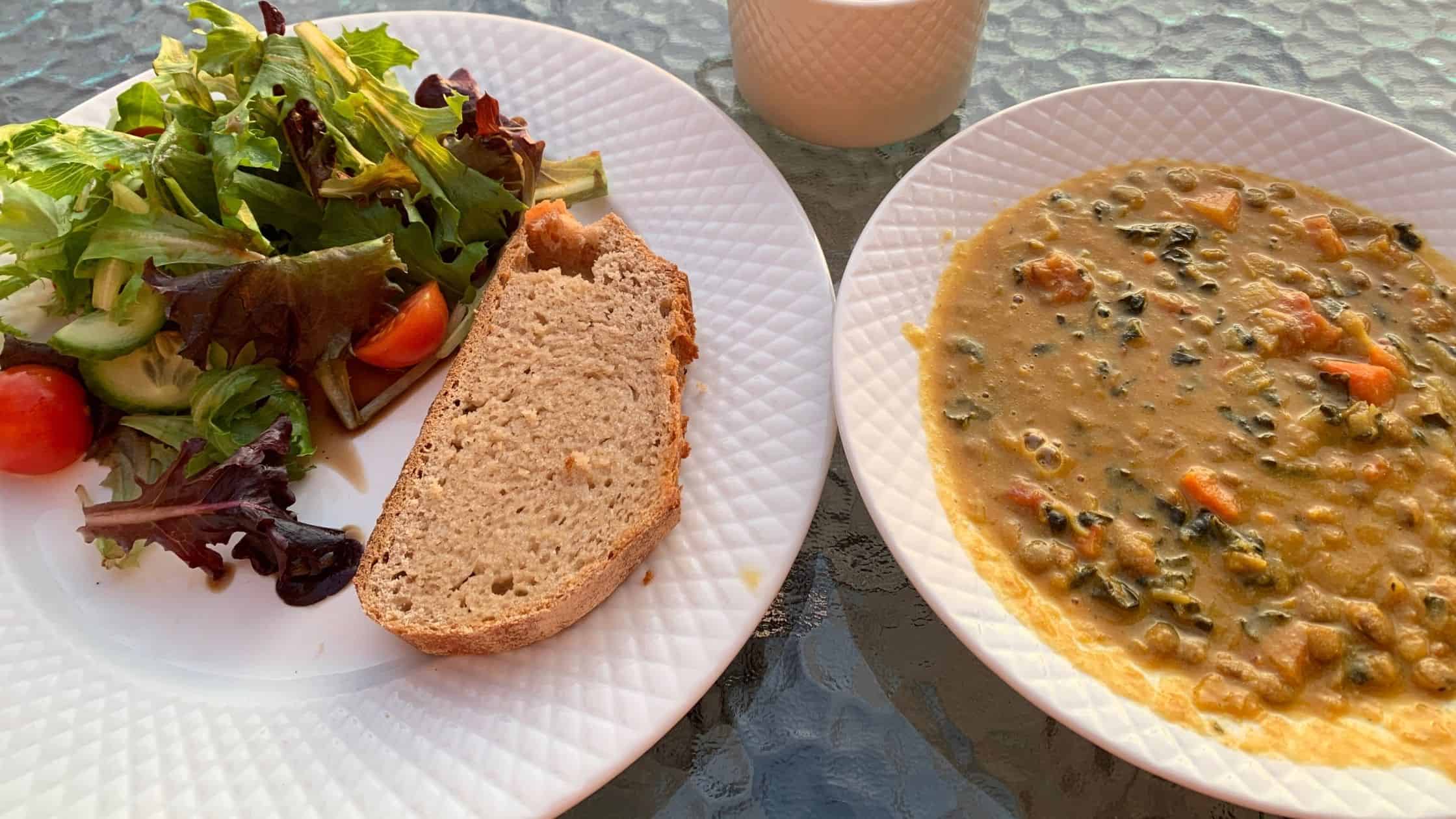A plate of salad and homemade bread beside a delicious soup - all made with fresh ingredients from the garden on the Sunshine Coast
